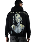 A man shown from the back wearing a black hoodie with a large graphic print of Marilyn Monroe and the text 'F*CK BEING NICE' across the upper back.